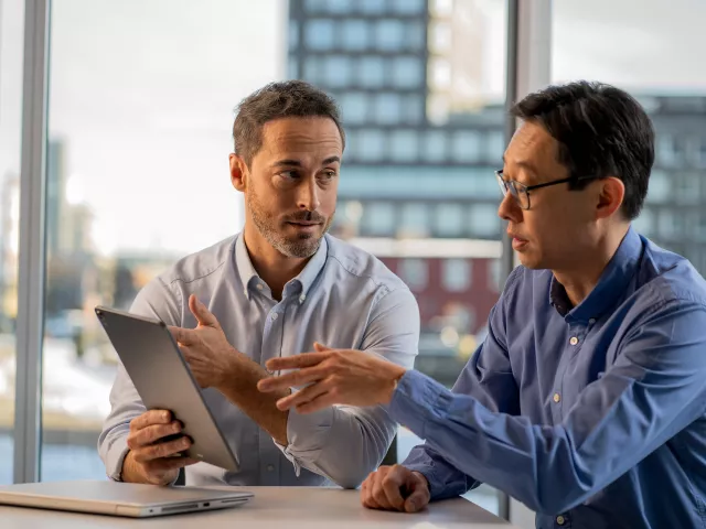 Two men discussing over tablet