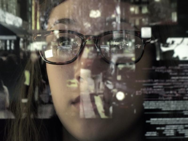 women with glasses looking at a screen