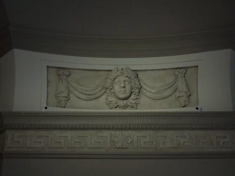 Two cameras mounted by stone work at museum