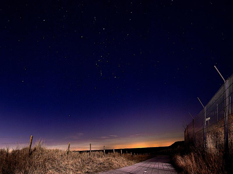 Path along a fence at night 