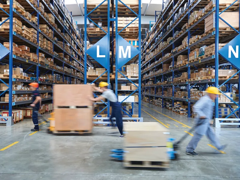 warehouse with staff moving pallet loaders
