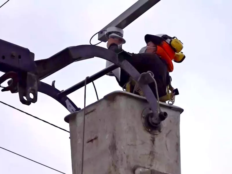 Crew worker installing camera on traffic pole