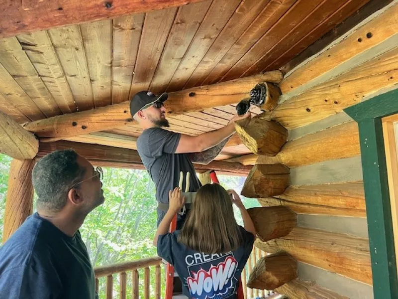 3 workers installing cameras on cabin