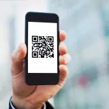 휴대폰을 들고 있는 손, QR 코드가 표시된 화면