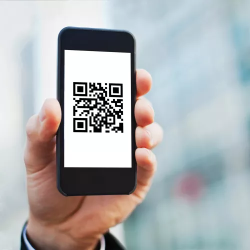 Mano con un teléfono, pantalla que muestra un código QR